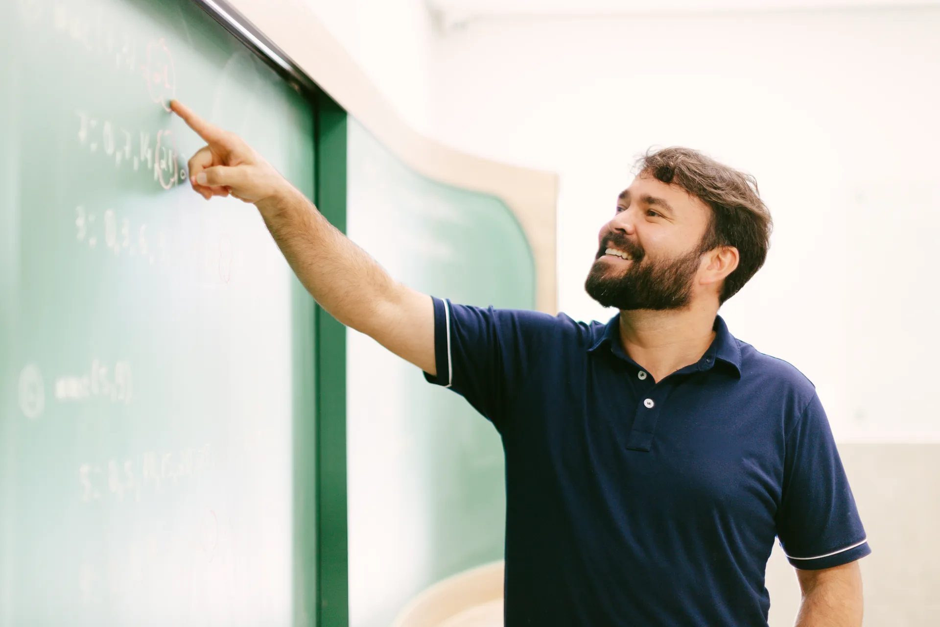 Professor apontando no quadro verde